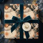 Celestial wrapping paper with a vintage sun and moon design and teal velvet ribbon by Wrapped Studios.