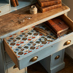 Vintage book wrapping paper by Wrapped Studios used as a drawer liner in a rustic wooden desk.