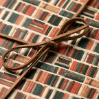 Book lovers wrapping paper with a vintage bookshelf pattern and rustic brown bow by Wrapped Studios.