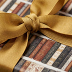 Vintage book wrapping paper tied with a gold ribbon. Literary gift wrap by Wrapped Studios.