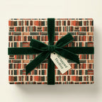 Book lover wrapping paper with bookshelf pattern, green velvet ribbon, and Wrapped Studios tag.