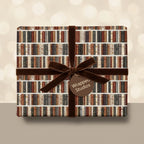 Vintage bookshelf wrapping paper on a gift box with a brown velvet ribbon, by Wrapped Studios.