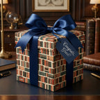 Book lover graduation wrapping paper with a navy satin bow on a study desk by Wrapped Studios.