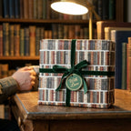 Vintage library book wrapping paper with green velvet ribbon on a cozy desk, by Wrapped Studios.