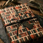 Vintage library book wrapping paper by Wrapped Studios on a gift box tied with rustic black twine.