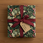 Elegant gift wrapped in floral wrapping paper with burgundy ribbon, ideal for Christmas or any joyous occasion.