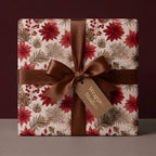 Elegant Christmas gift wrap with red floral poinsettia pattern and brown satin bow by Wrapped Studios.