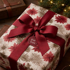 Vintage Christmas wrapping paper with red poinsettias and a burgundy bow. Luxury gift wrap by Wrapped Studios.