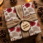 Rustic Christmas wrapping paper with red poinsettias and burlap ribbon on wood by Wrapped Studios.