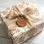 Luxury vintage botanical wrapping paper by Wrapped Studios on a gift box with a beige velvet ribbon.