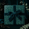 Botanical emerald green Christmas wrapping paper with a luxury velvet bow, by Wrapped Studios.