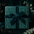 Botanical emerald green Christmas wrapping paper with a luxury velvet bow, by Wrapped Studios.
