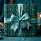 Luxury botanical Christmas wrapping paper with a teal satin bow by Wrapped Studios.