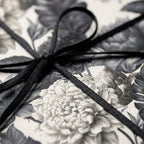 Luxury vintage floral wrapping paper in black and white, tied with a thin black ribbon bow by Wrapped Studios.