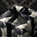 Vintage black and white floral wrapping paper with a luxury satin bow and gift tag by Wrapped Studios.