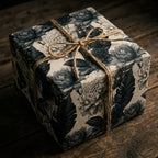 Vintage floral wrapping paper with dark botanical print and twine bow on rustic gift box by Wrapped Studios.