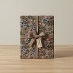 Elegant gift wrapped in vintage floral wrapping paper with blue flowers and a satin ribbon.
