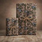 Two gifts wrapped in vintage floral wrapping paper with twine bows on a wooden surface.