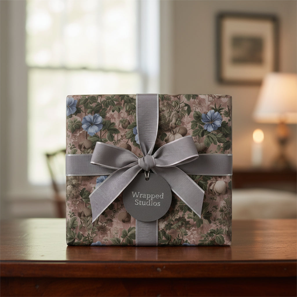 Elegant floral wrapping paper with blue blossoms, tied with a silver ribbon and bow on a gift box.
