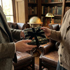 Luxurious wrapping paper with vintage ornament design & black velvet bow for elegant holiday gifts. Wrapped Studios.