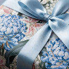 Luxury blue floral wrapping paper with a light blue satin ribbon bow by Wrapped Studios.