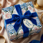 Luxury floral wrapping paper by Wrapped Studios on a gift box tied with a royal blue velvet ribbon.