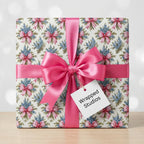 Vintage floral wrapping paper with blue flowers and a pink satin ribbon on a gift box by Wrapped Studios.
