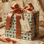 Elegant gift wrapped in unique beetle-patterned wrapping paper with a satin bronze ribbon and bow.