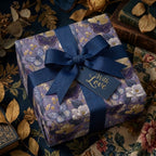Luxury floral and butterfly wrapping paper with navy ribbon and With Love tag by Wrapped Studios.