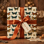 Elegant square gift wrapped in butterfly print paper with a copper ribbon bow.
