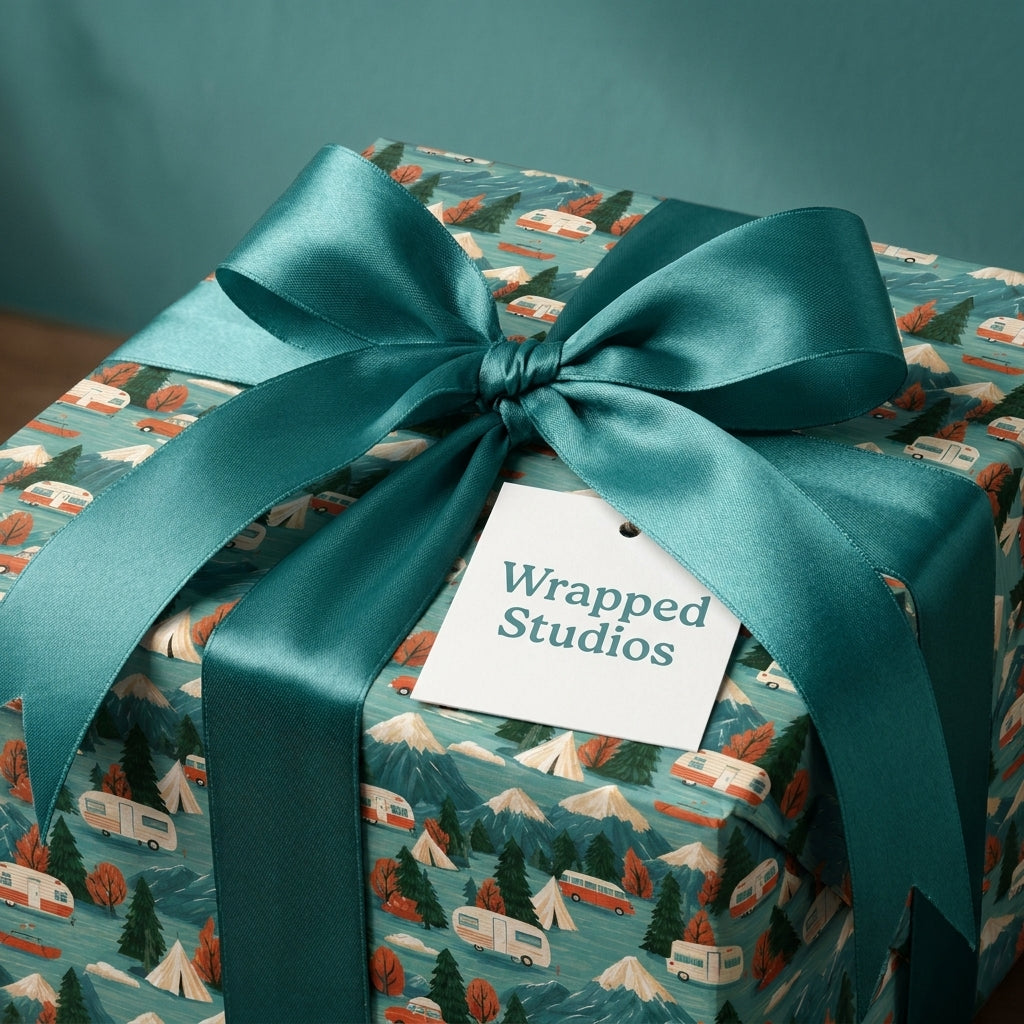 Vintage camper wrapping paper with mountains, tied with a teal satin bow by Wrapped Studios.