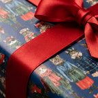 Whimsical winter cat wrapping paper with a red satin ribbon, cute holiday gift wrap by Wrapped Studios.