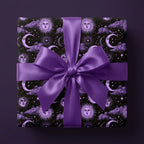 Purple celestial wrapping paper with vintage sun and moon patterns and a satin bow, by Wrapped Studios.