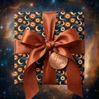 Celestial wrapping paper with mystical sun and moon pattern and satin copper bow by Wrapped Studios.