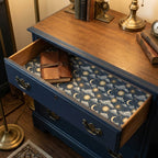 Celestial wrapping paper with gold sun and moon pattern lining a vintage drawer by Wrapped Studios.