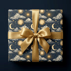 Luxury celestial gift wrap with navy and gold sun and moon pattern and satin ribbon bow, by Wrapped Studios.