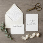 Elegant wedding invitation mockup with deckled edge cards, silk ribbon, and eucalyptus by Wrapped Studios.