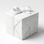 Elegant white floral wedding wrapping paper with a white ribbon bow on a gift box by Wrapped Studios.