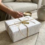 Elegant cream damask luxury gift wrap with a gold twine bow by Wrapped Studios.