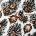 Vintage Christmas gift wrap with pinecones, ornaments, and bronze twine bow by Wrapped Studios.