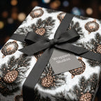 Luxury holiday gift wrap with a vintage pinecone pattern and black grosgrain bow by Wrapped Studios.