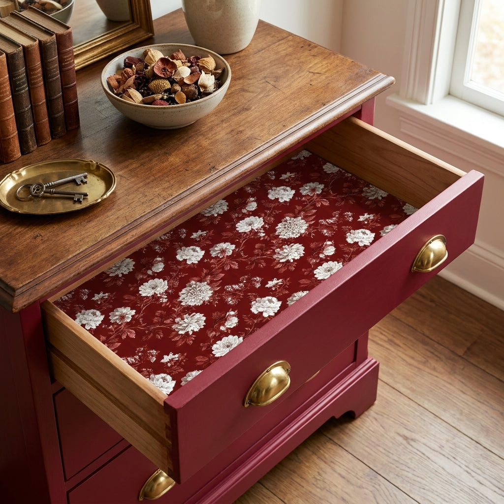 Vintage burgundy floral wrapping paper lining a wooden dresser drawer by Wrapped Studios.