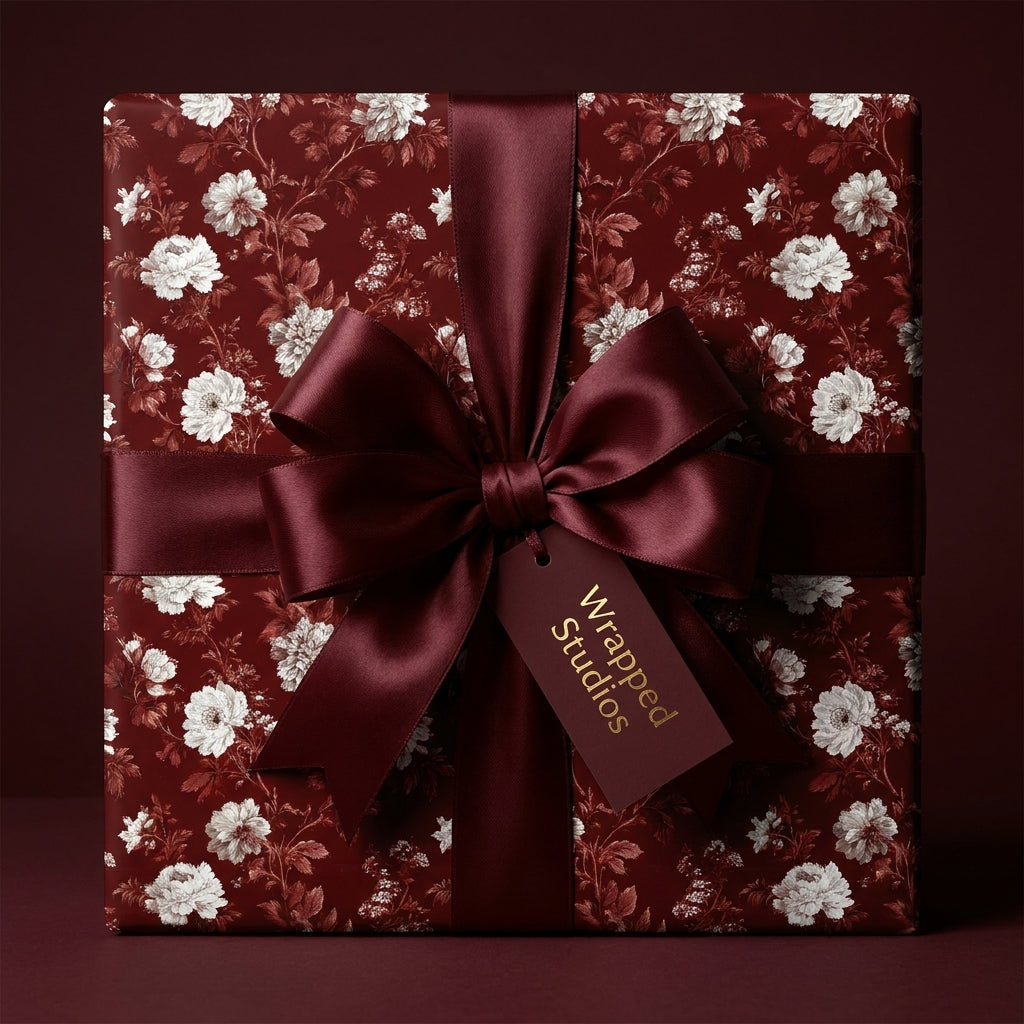 Luxury burgundy floral wrapping paper with a large satin bow and gift tag from Wrapped Studios.