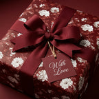 Luxury burgundy floral wrapping paper with a matching ribbon and 'With Love' tag by Wrapped Studios.