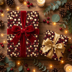 Luxury burgundy and gold Christmas wrapping paper with elegant bows by Wrapped Studios on a festive wooden table.