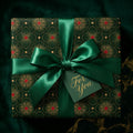 Luxury green and gold holiday wrapping paper with a satin ribbon and tag by Wrapped Studios.