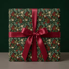 Vintage botanical berry Christmas wrapping paper with a red satin bow by Wrapped Studios.