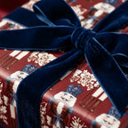 Luxury burgundy nutcracker Christmas wrapping paper with a navy velvet bow by Wrapped Studios.