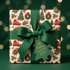 Vintage Christmas gift wrap featuring red trucks and a green bow by Wrapped Studios.