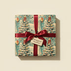 Square gift wrapped in vintage-style Christmas tree wrapping paper with a red satin bow.